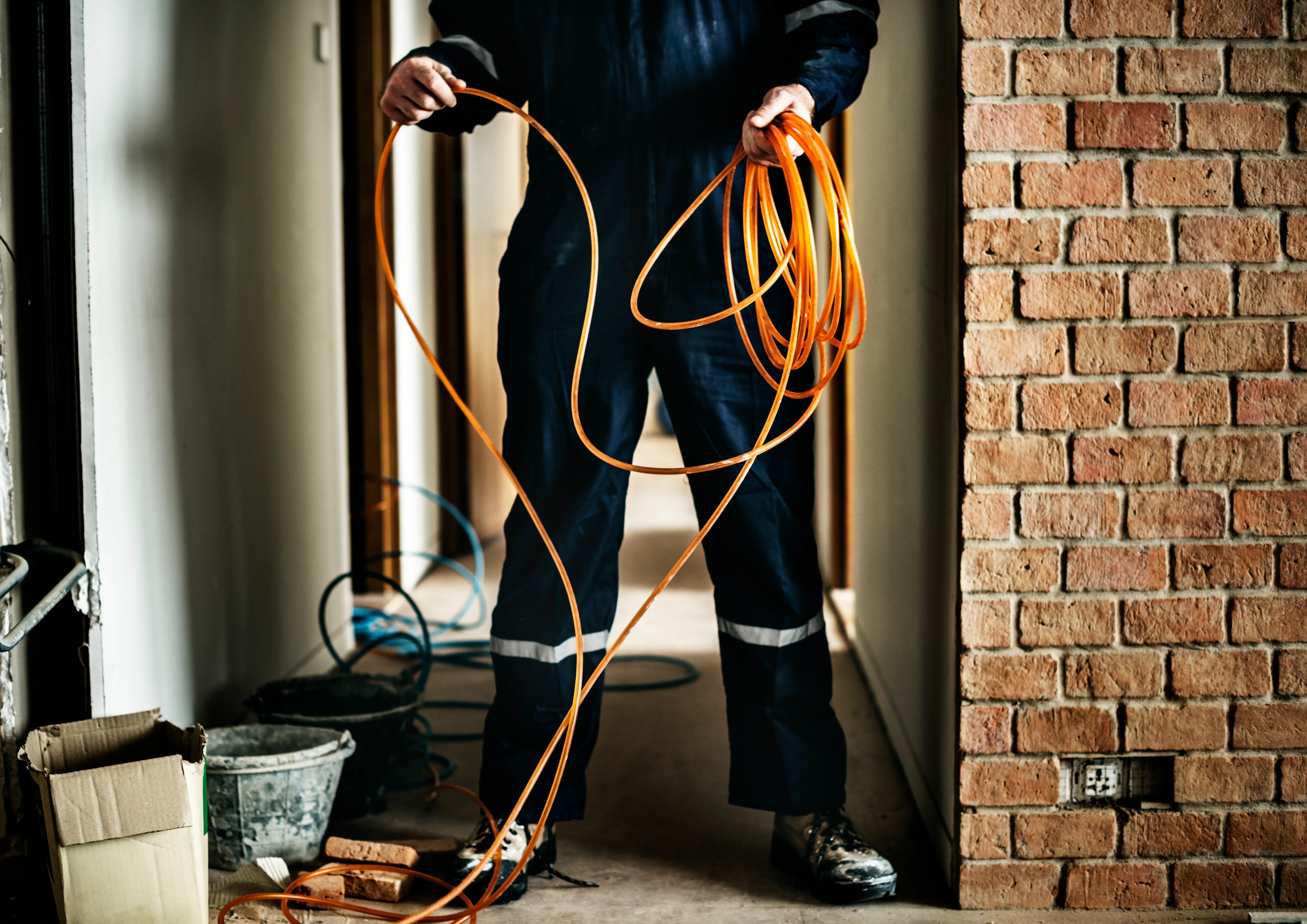 Håndværker arbejder med kabel på byggeplads